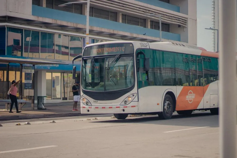 City bus stopped at a curb with passengers boarding, illustrative of curbside intercity bus boarding