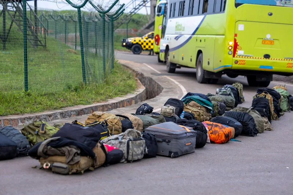 Backpacks and luggage lined up next to a bus, illustrative of packing for intercity bus travel