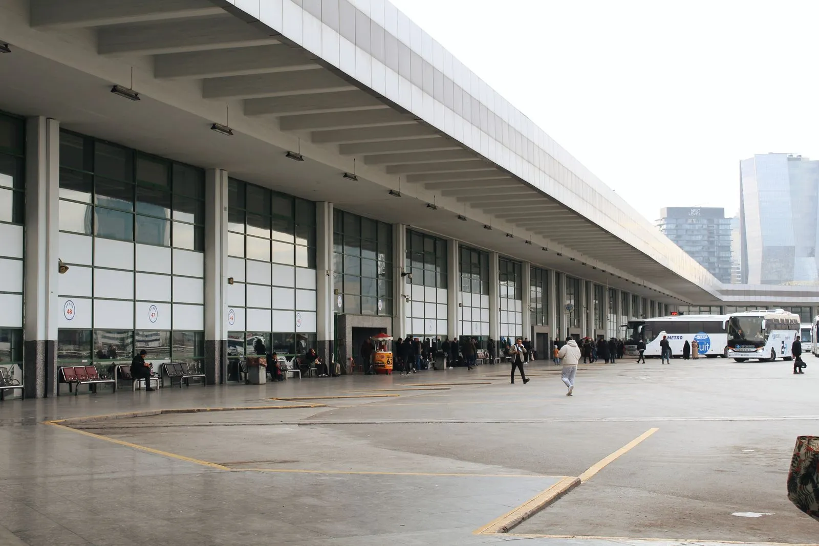 Passengers waiting at a busy intercity bus terminal, illustrative of coach operator boarding areas